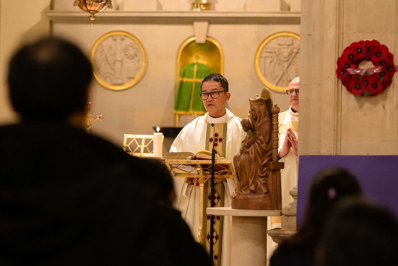 Priest at front of church speaking to congregation