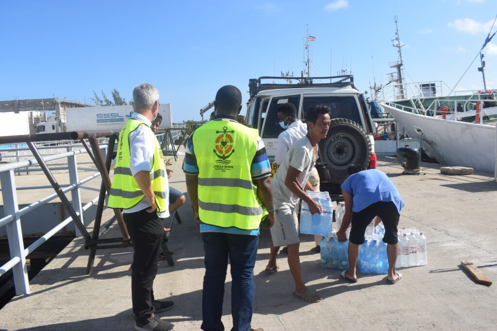Fishers receiving water from a Stella Maris chaplain