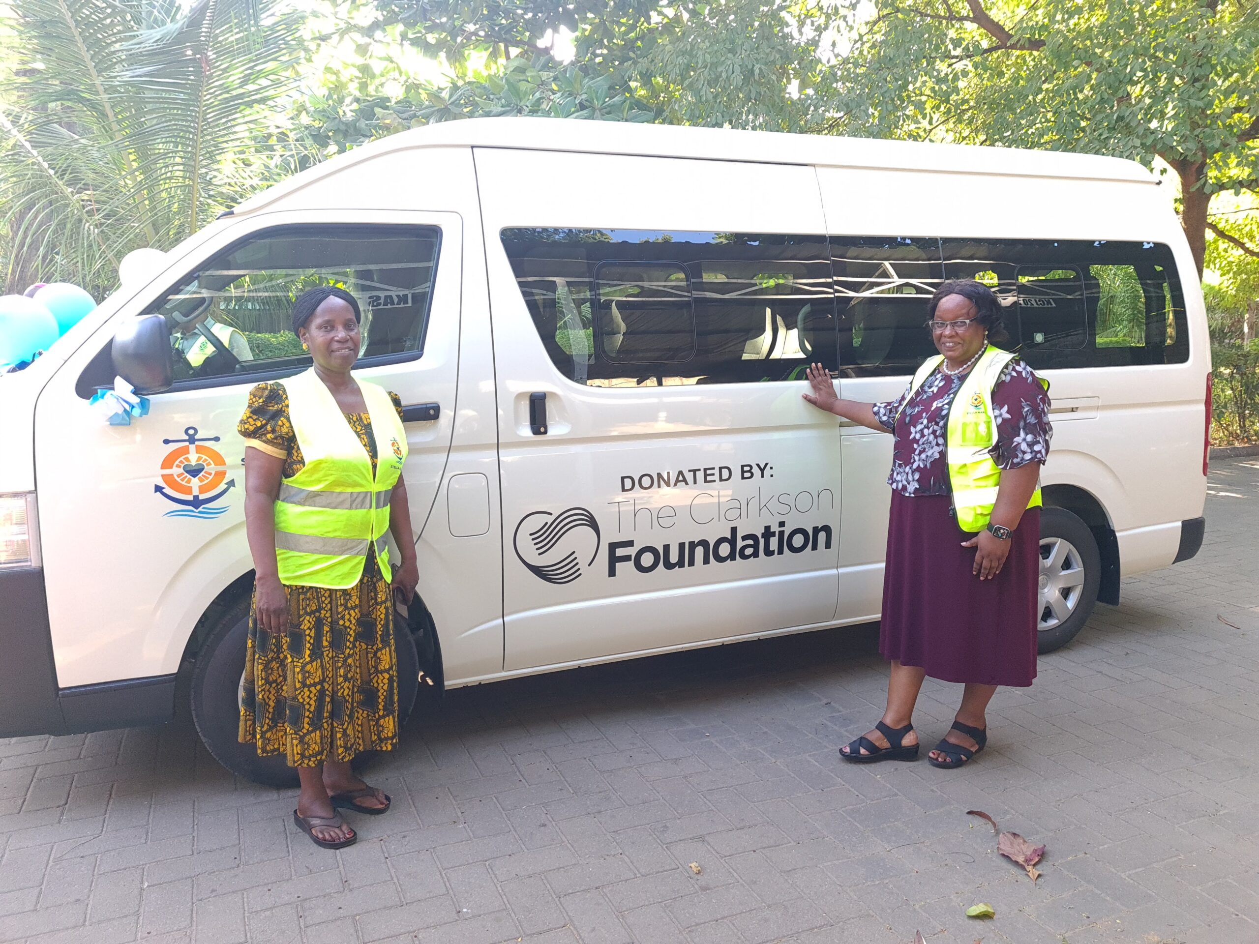 New van with Margaret Masibo and a volunteer standing proudly next to it